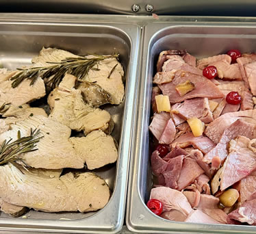 Hand-carved turkey and spiral ham in serving trays